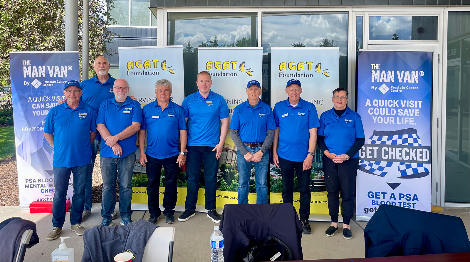 MAN VAN® volunteer team posing in blue shirts at event.
