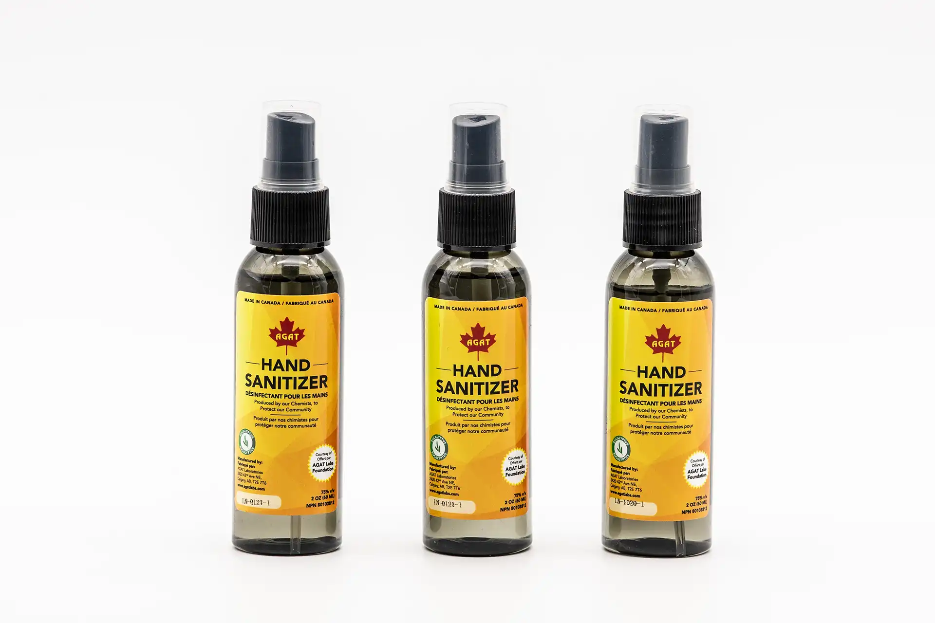 Three bottles of AGAT Laboratories hand sanitizer labeled “Made in Canada” displayed on a white background.