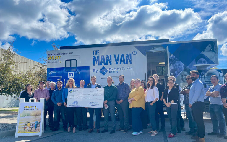 Group of people standing in front of the MAN VAN mobile clinic, holding a large cheque, with AGAT Foundation and Prostate Cancer Centre branding visible.